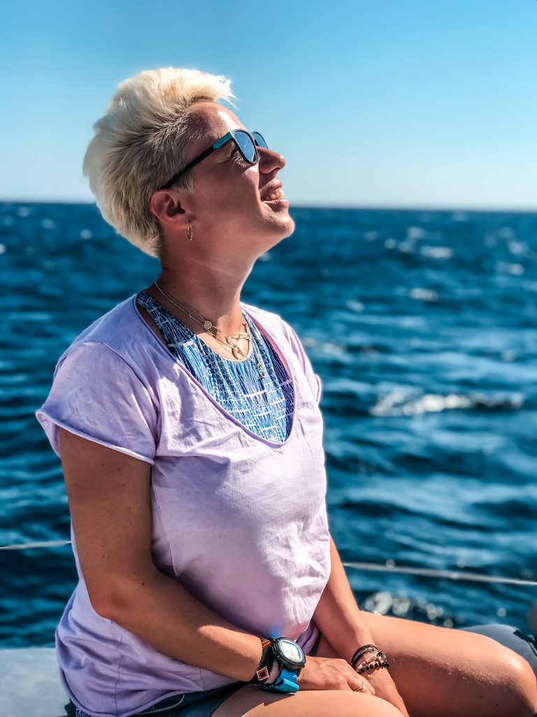 Rejs na Santorini, kobieta w okularach przeciwsłonecznych, w tle morze, słoneczny dzień 