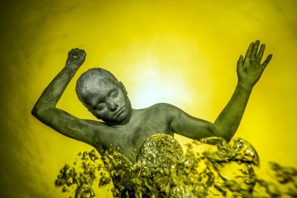 dziecko unoszące się na wodzie, woda złotego koloru
